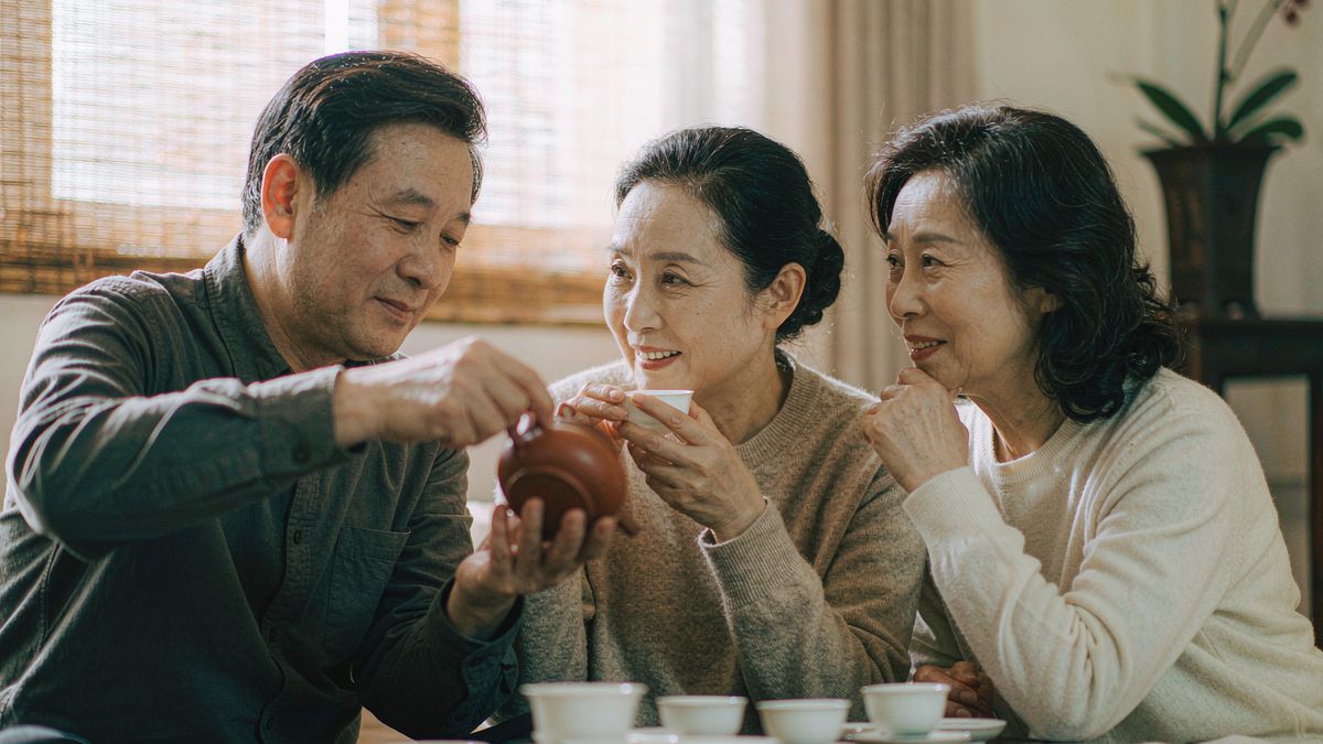 三位朋友在茶室围坐品茶聊天